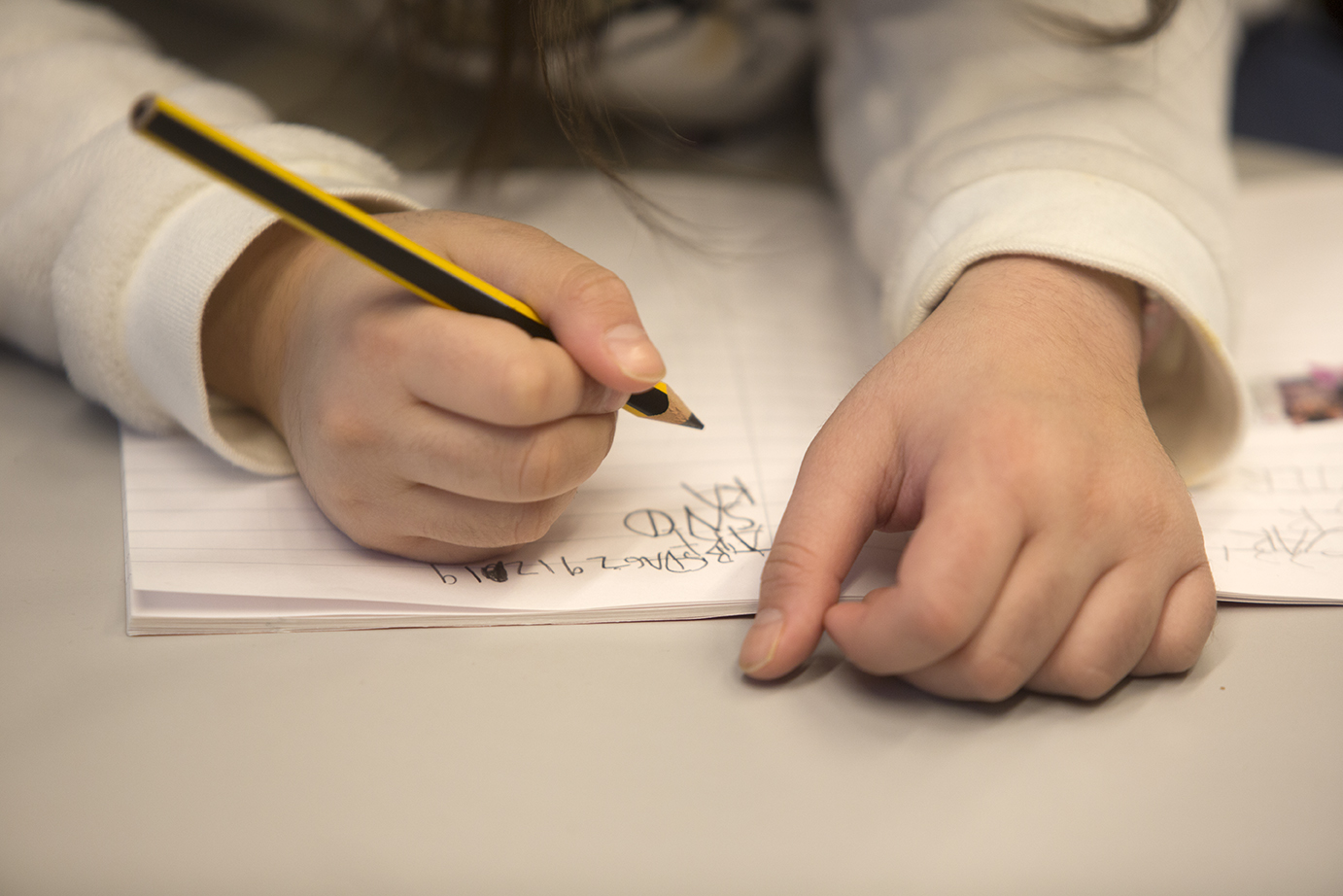 Bilde viser to barnehender og en notatblokk. Holder i en blyant og skriver på notatblokken ©NAKU
