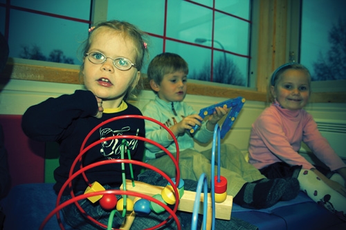 Flere barn som sitter på gulvet og leker