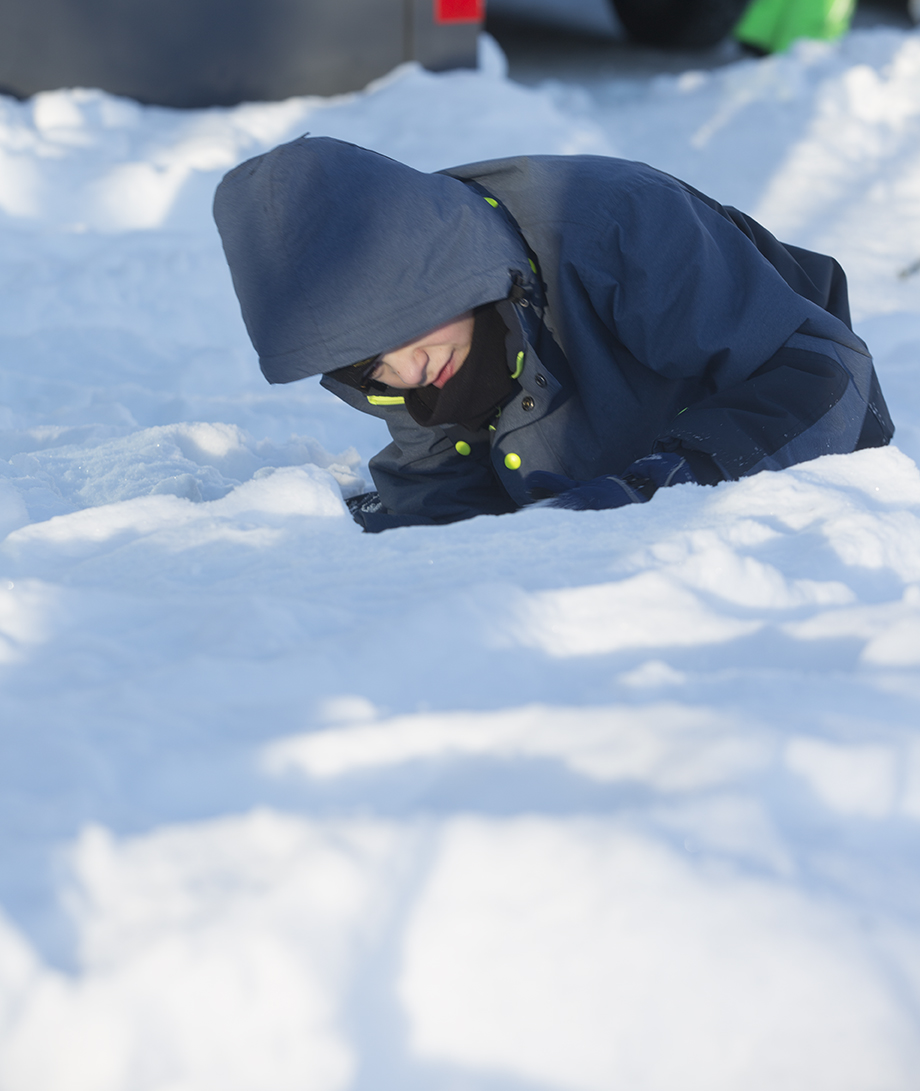 Et barn leker i snøen