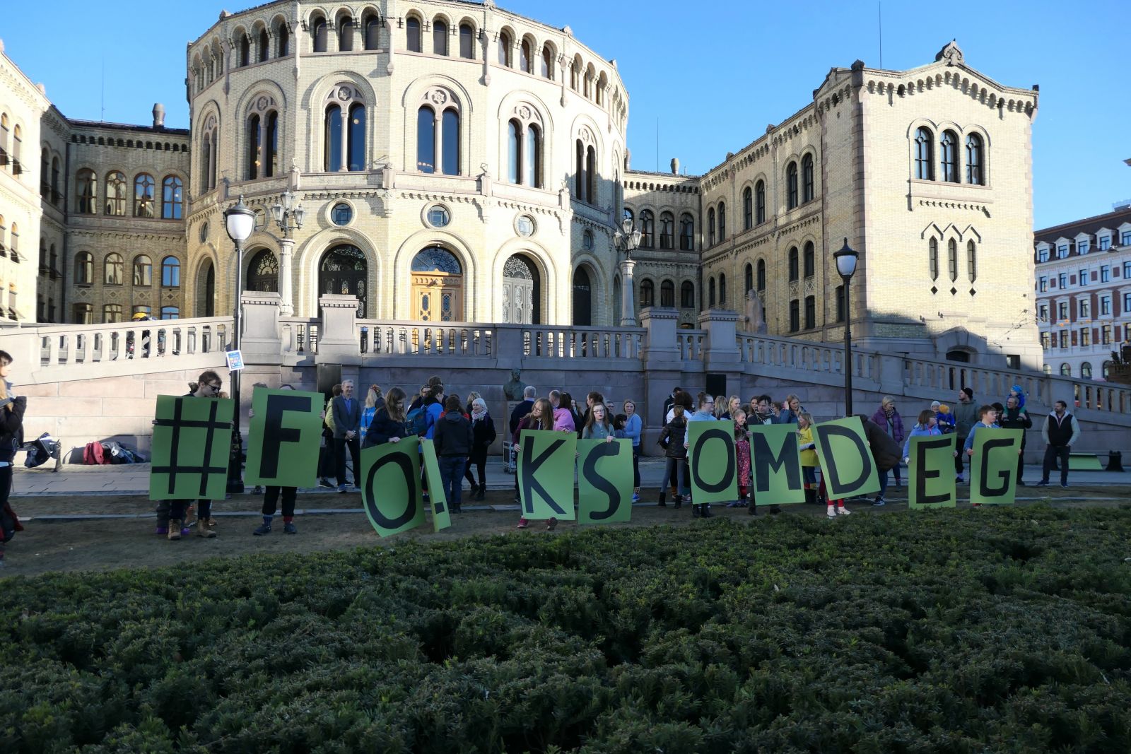 Bilde fra arrangement utenfor stortinget med plakater som viser #folksomdeg