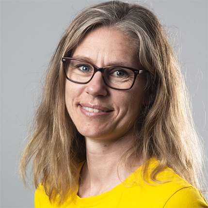 Portrettbilde. Dame ser mot fotografen og smiler. 