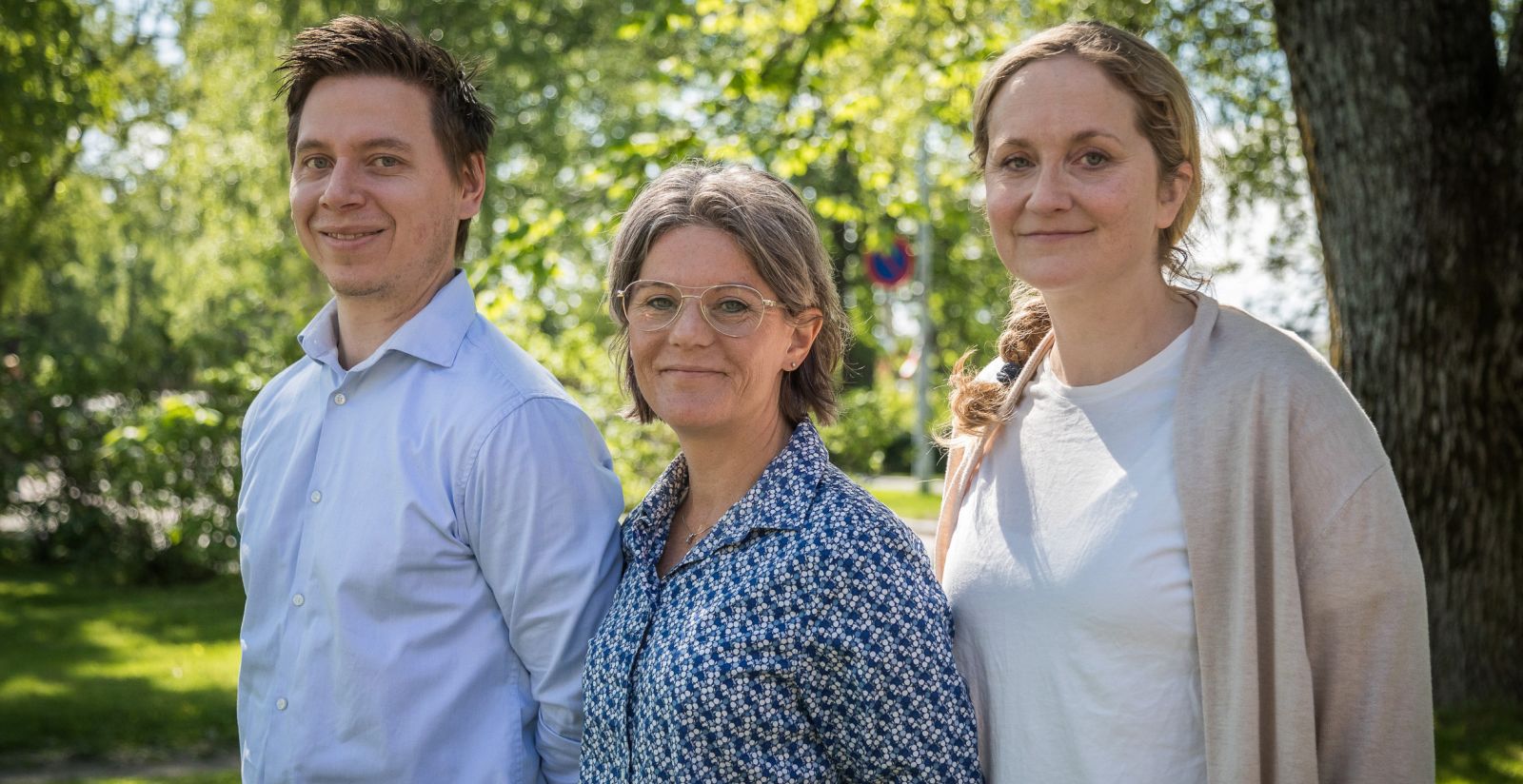 Tre personer står utendørs, alle tre ser mot kameraet og smiler ©Otto von Munchow