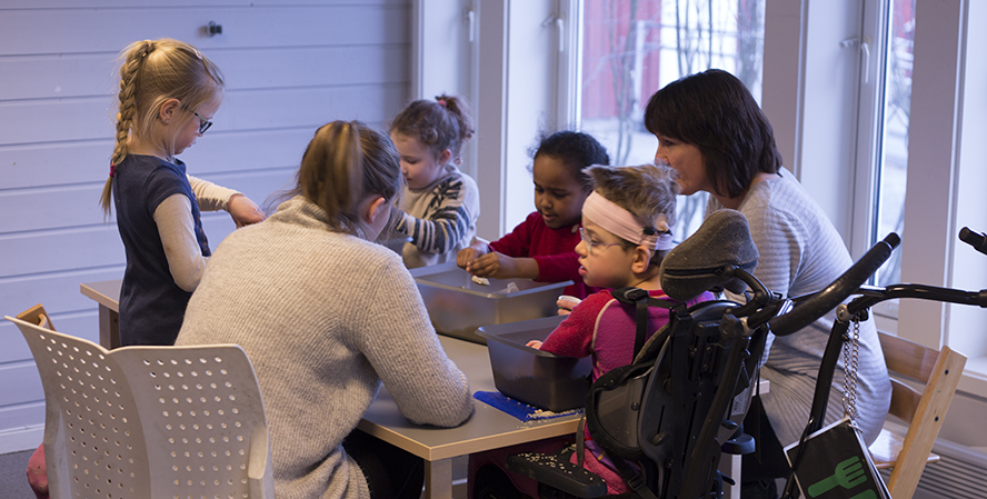 Flere barn og voksne som sitter rundt et bord